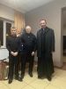 Seniorzy pozują do zdjęcia z proboszczem